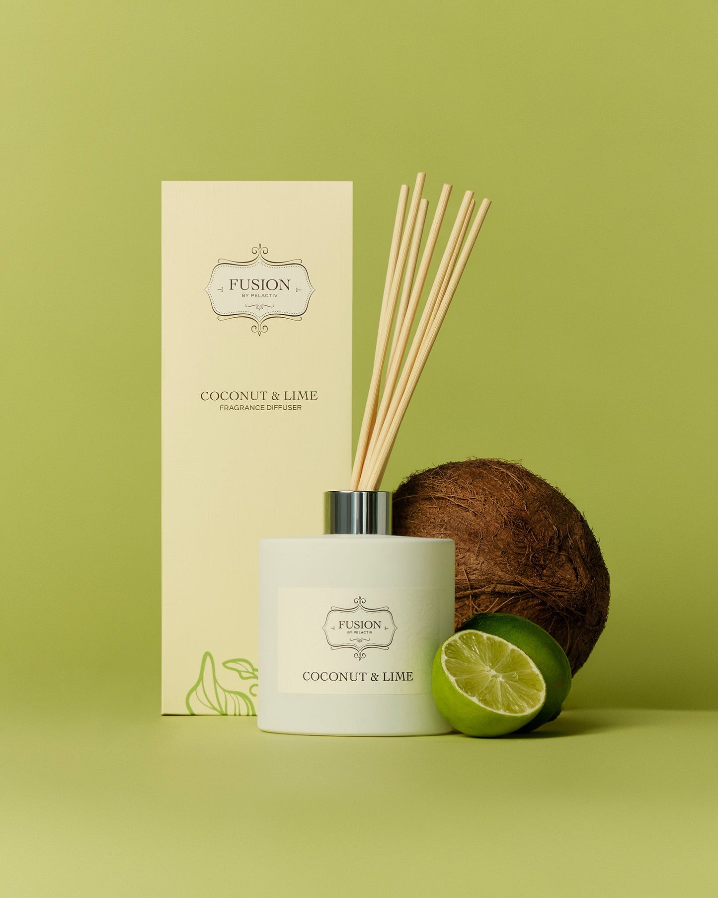 Diffuser with reeds, labeled "Coconut & Lime," next to a coconut and halved lime on a green background. Calm and refreshing ambiance.